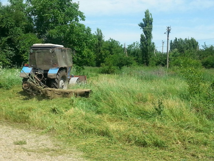 Покос сорной растительности трактором на территории поликлиники
